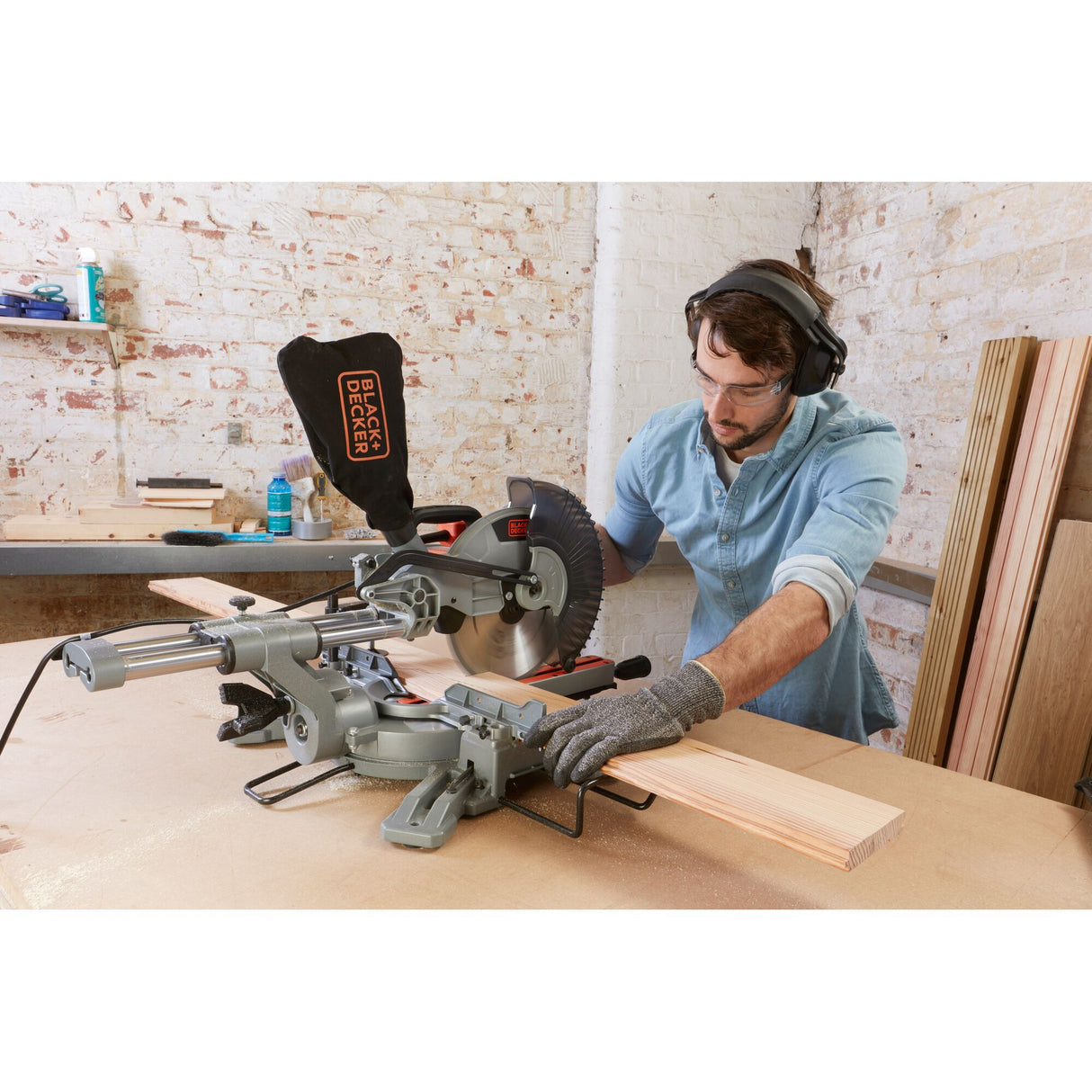 Scie à onglet grise BLACK+DECKER en action, outil électrique pour bois, couleur grise.