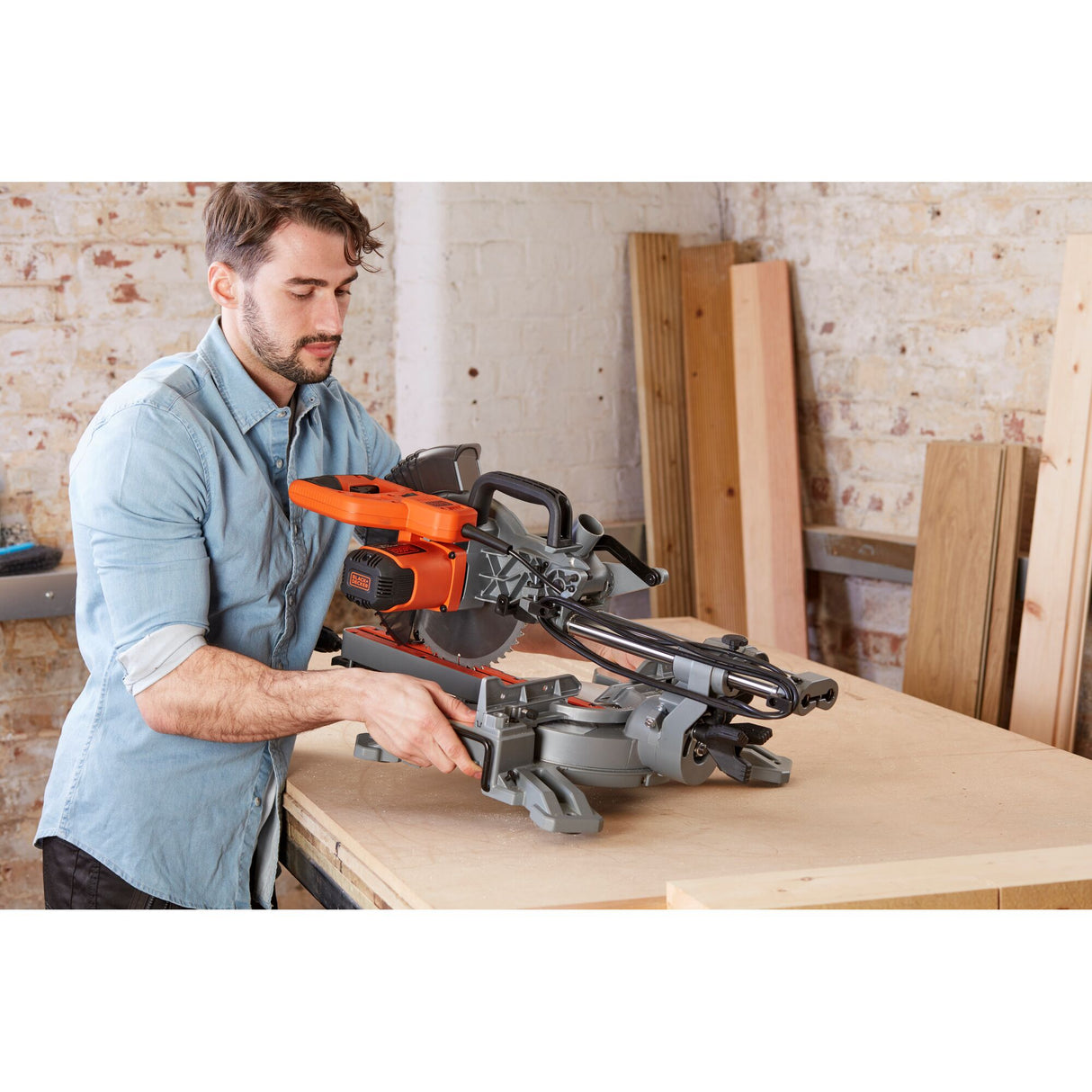 Scie radiale Black+Decker, outil électroportatif, couleur orange et gris, utilisée sur établi.
