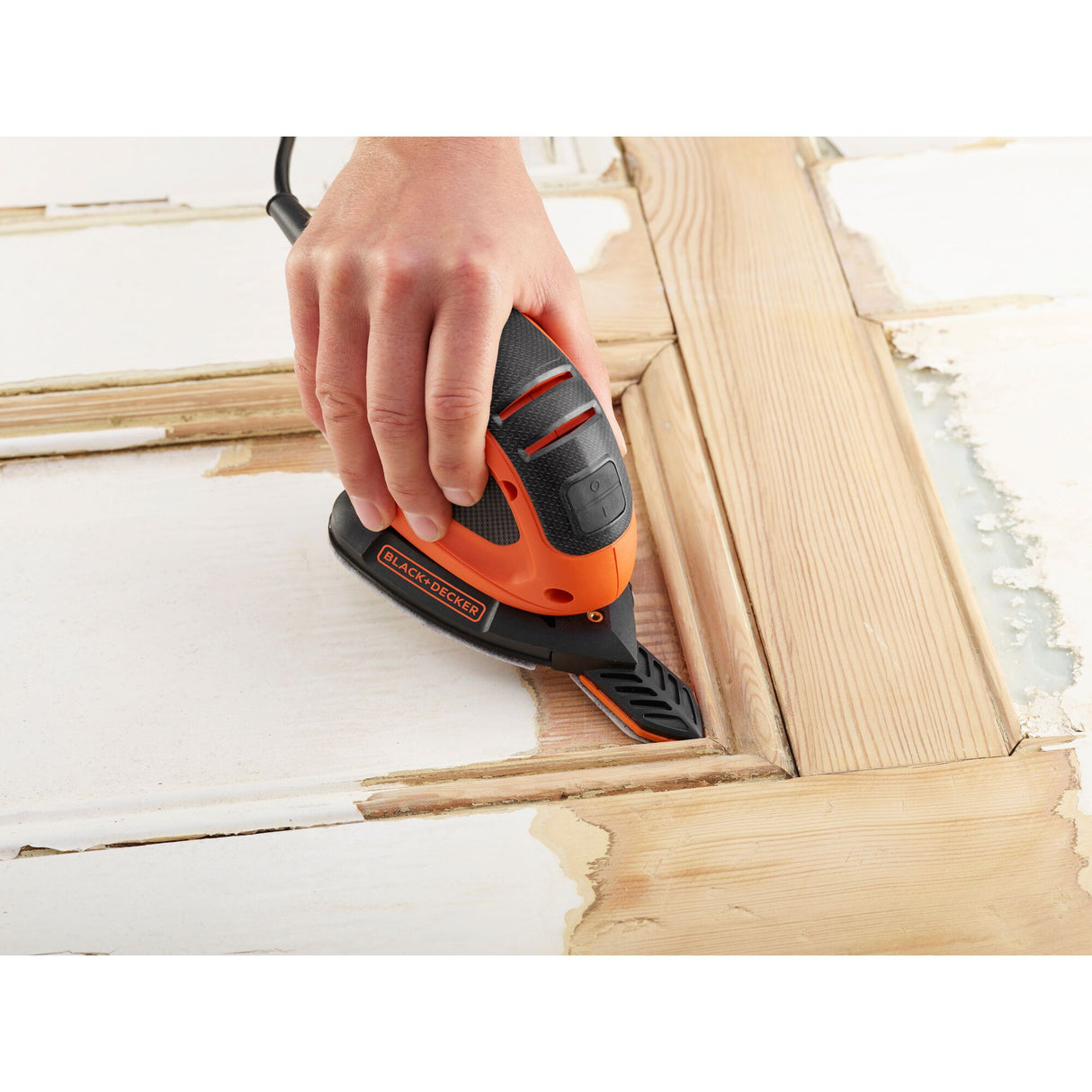 Ponceuse électrique Black+Decker, type souris, couleur orange et noire, en action sur bois.
