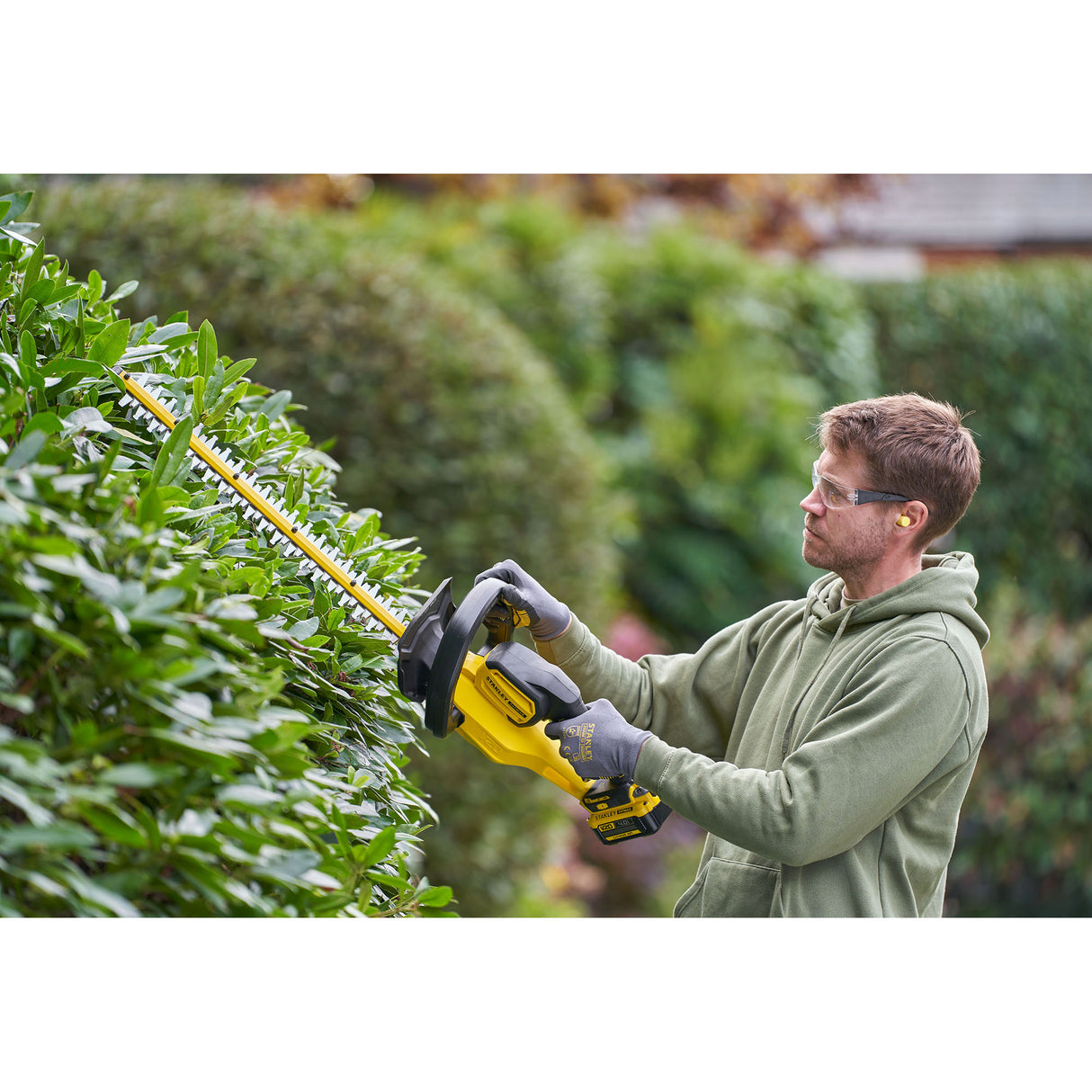 Taille-haie jaune DeWalt, outil de jardinage motorisé, utilisé en extérieur