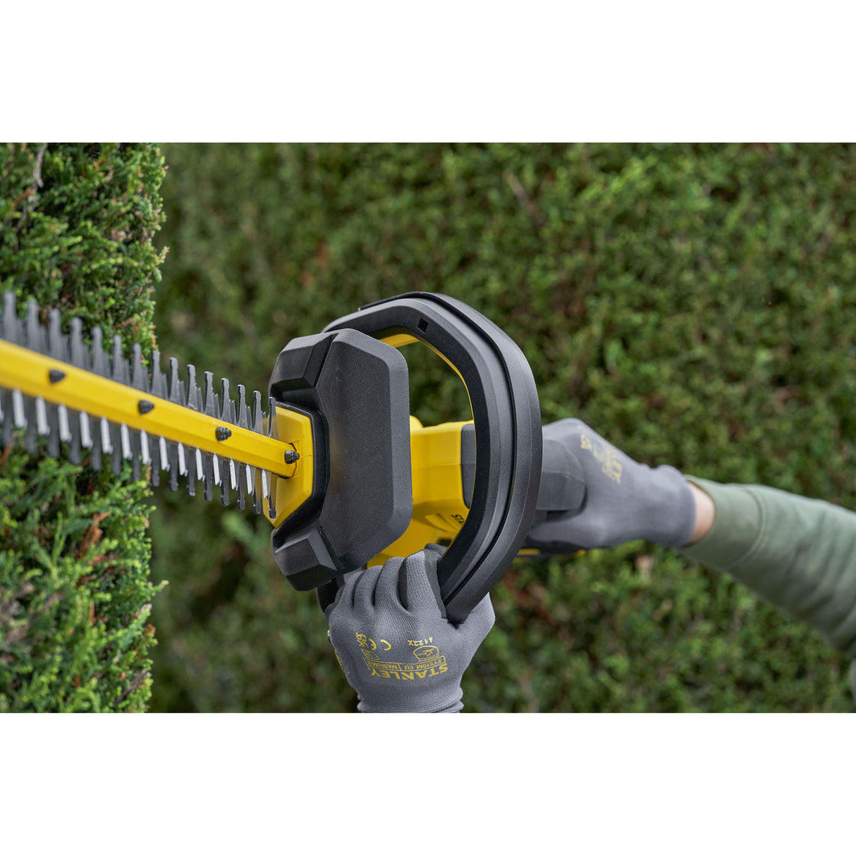 Taille-haie Stanley jaune et noir, outil électrique pour jardinage en action