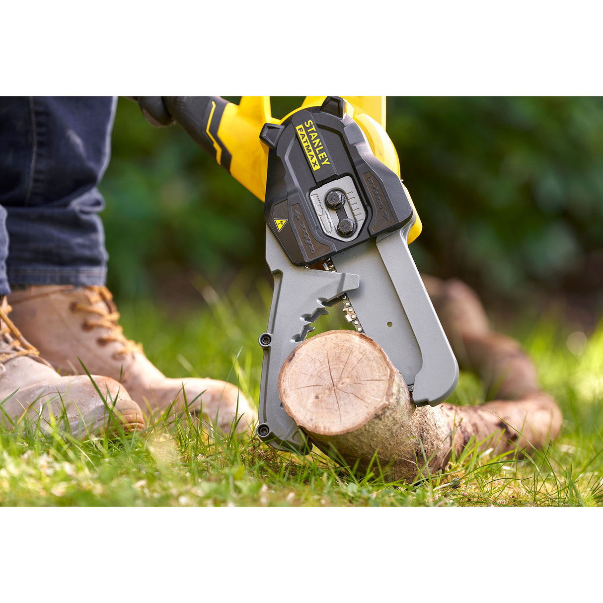Scie électrique Stanley, outillage jaune et noir, coupe une branche en extérieur.