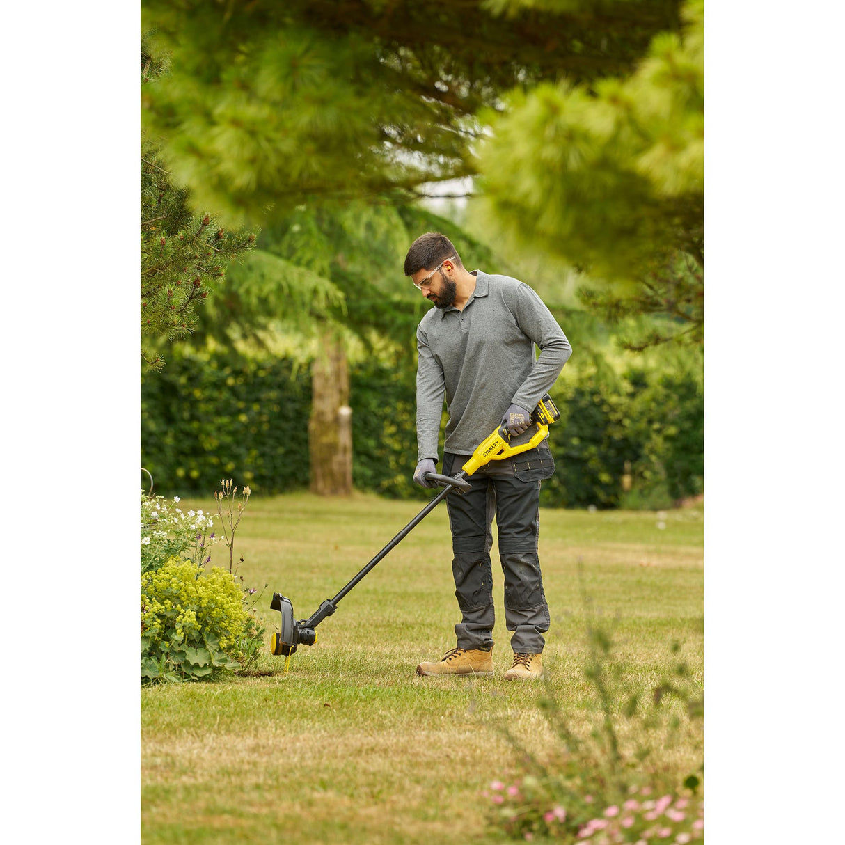 Homme utilisant un coupe-bordure jaune Dewalt pour gazon, outil de jardinage électrique.