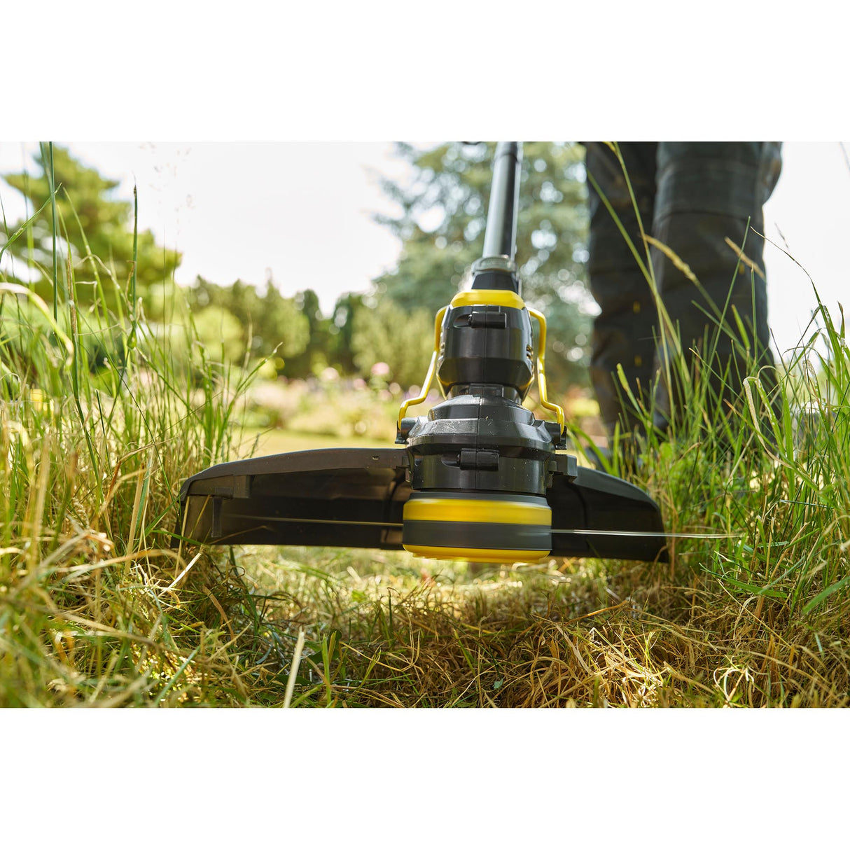 Taille-bordures jaune et noir de la marque Stanley en action dans un jardin