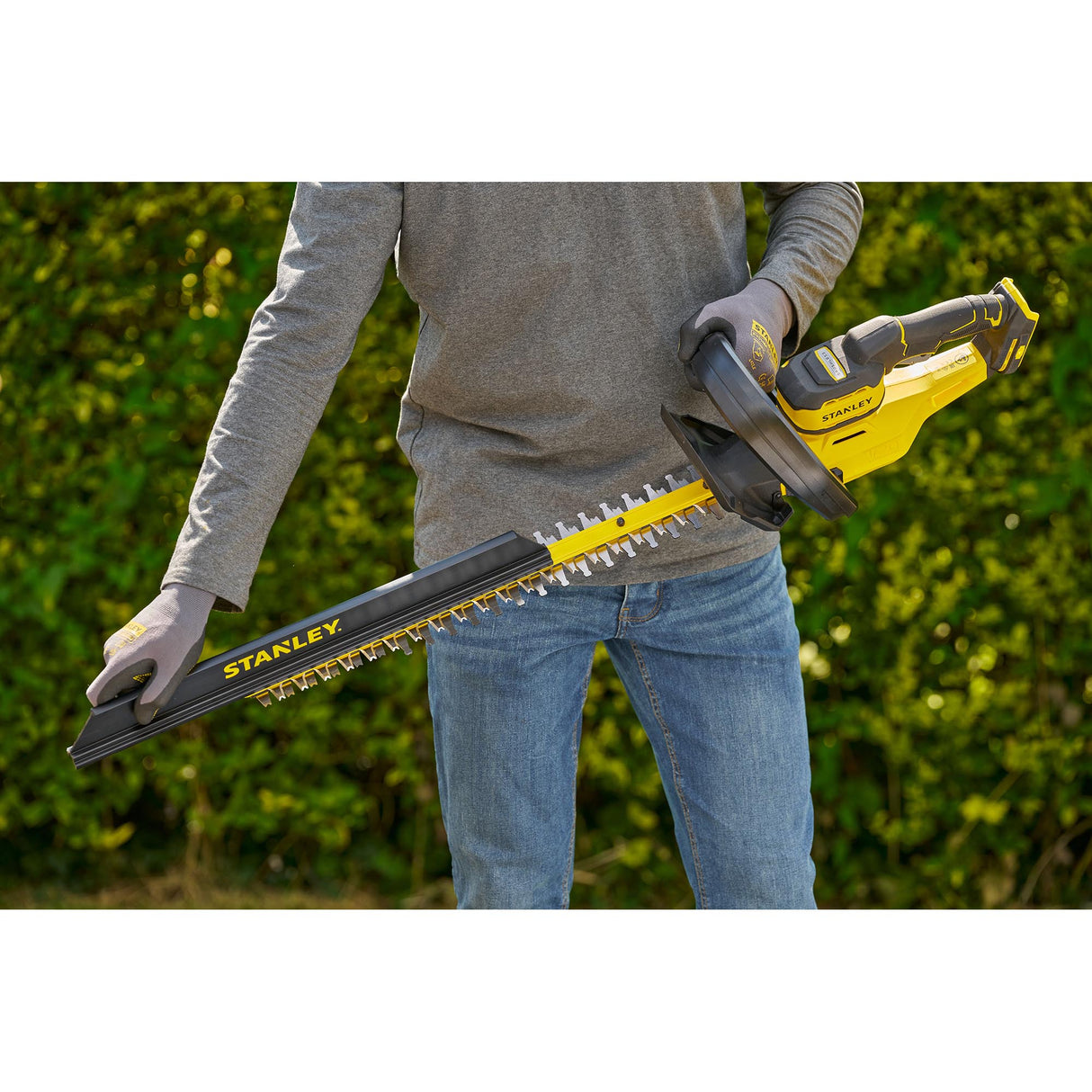 Taille-haie électrique Stanley jaune et noir, utilisé en extérieur, outil de jardinage