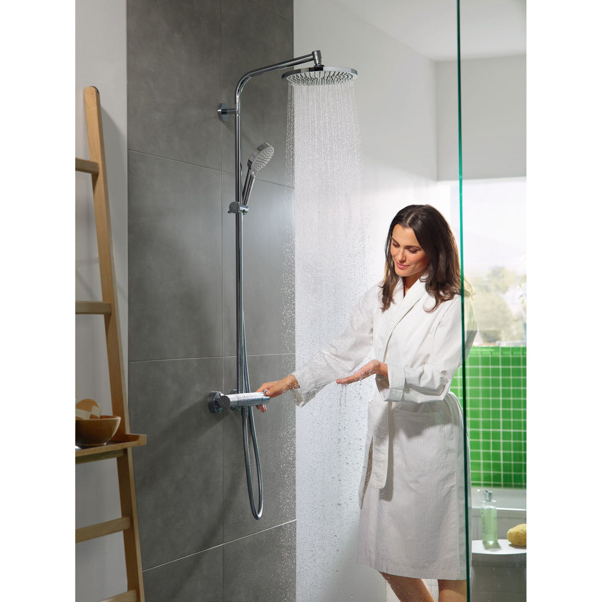 Douche Grohe, colonne de douche chromée, femme testant l'eau, salle de bain moderne gris et vert.