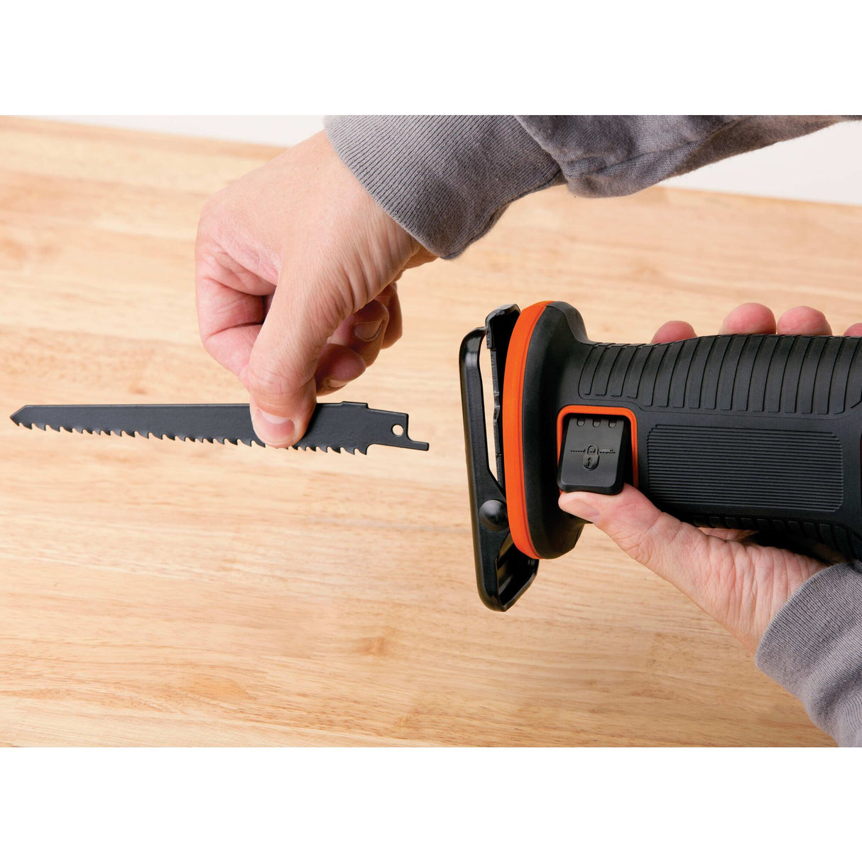 Scie sabre noire et orange de la marque Stanley, type outil électroportatif, sur table en bois.