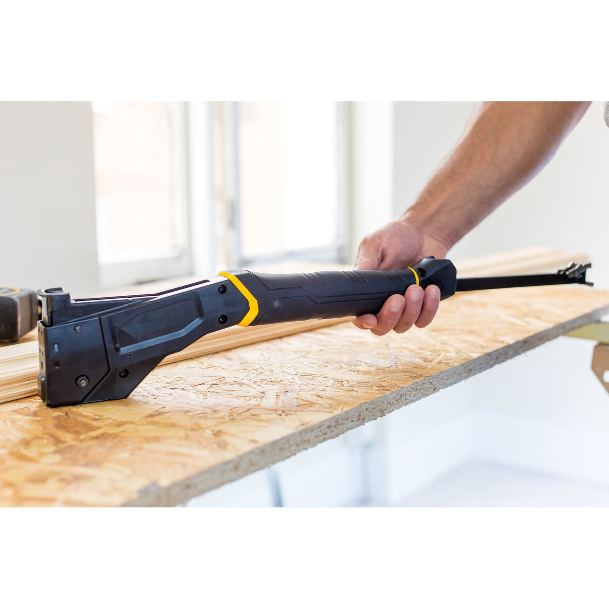 Agrafeuse Stanley, outil d'agrafage noir et jaune, utilisée sur du bois