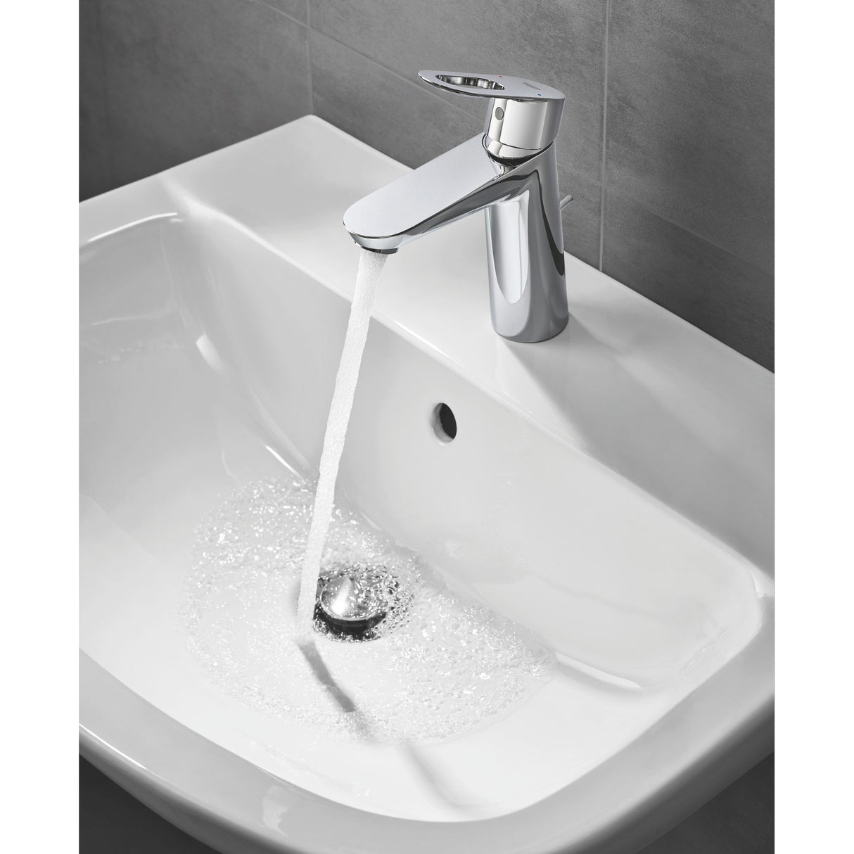 Robinet Grohe, mitigeur lavabo, couleur chrome argenté, eau coulant dans un évier blanc