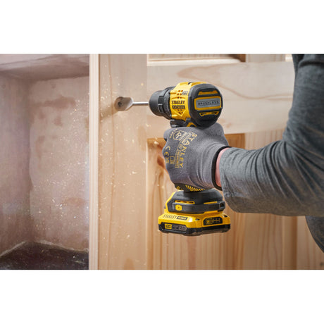 Perceuse visseuse sans fil Stanley, couleur jaune et noire, utilisée sur du bois