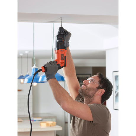 Perceuse électrique Black+Decker, outil électroportatif, couleur orange et noire, en usage