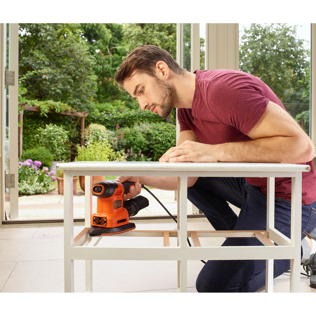 Ponceuse électrique Black+Decker, outillage orange utilisé sur meuble blanc