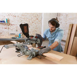 Scie à onglet grise BLACK+DECKER en action, outil électrique pour bois, couleur grise.