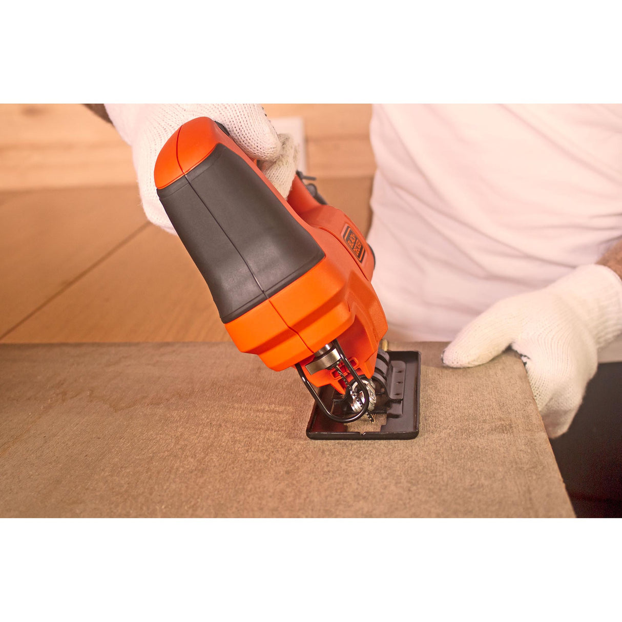 Scie sauteuse Black+Decker outil électroportatif orange en action sur bois