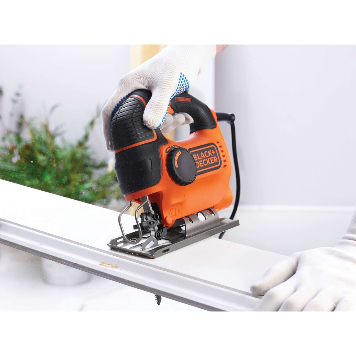 Scie sauteuse Black+Decker, outillage électroportatif, couleur orange et noire, en action.
