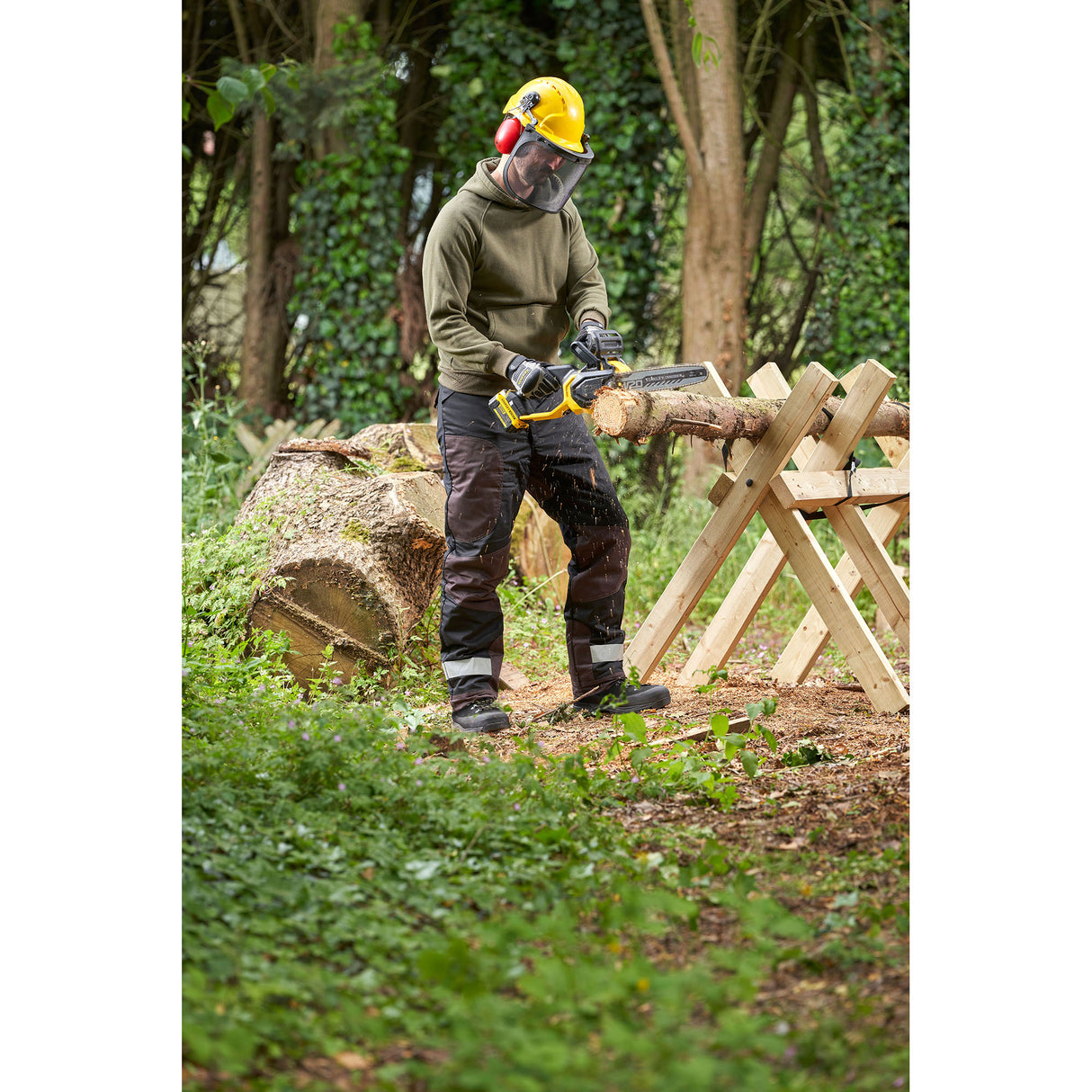 Tronçonneuse DeWalt jaune, outil d'élagage, utilisée en extérieur par une personne équipée.