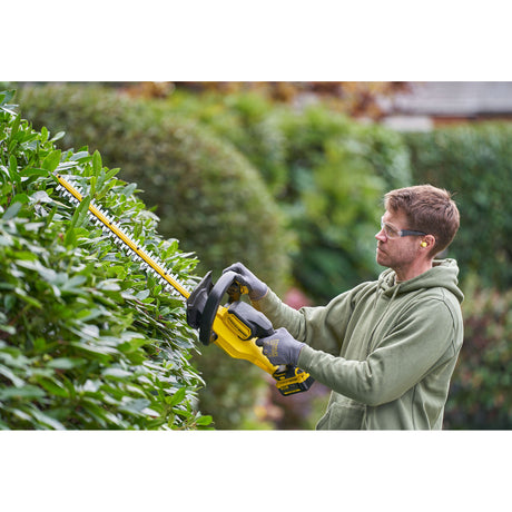 Taille-haie jaune DeWalt, outil de jardinage motorisé, utilisé en extérieur