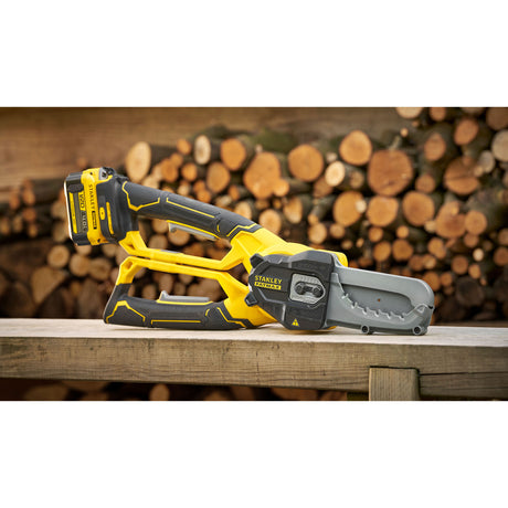 Tronçonneuse Stanley, outil électrique jaune et noir, posée sur une table en bois.