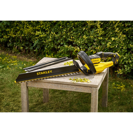 Taille-haie Stanley jaune et noir, outil de jardinage électrique posé sur une table en bois