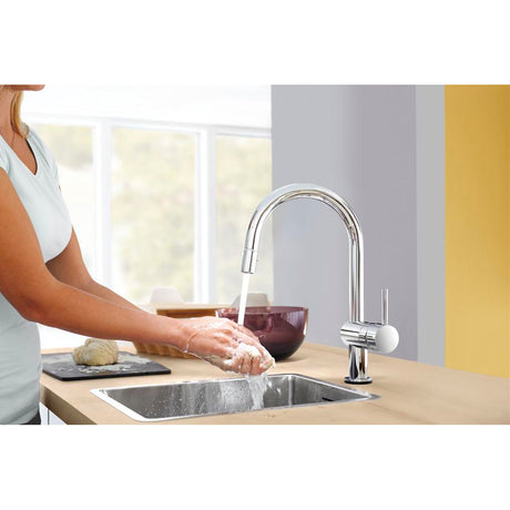 Mitigeur de cuisine Grohe, robinet chromé, femme lavant les mains à l'évier.