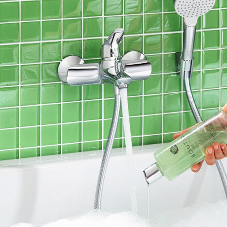 Mitigeur de baignoire Grohe chromé, robinet mural moderne, couleur argentée, devant carrelage vert