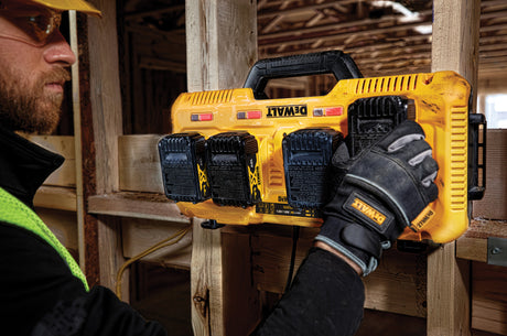 Chargeur de batteries DeWalt, type outillage électroportatif, couleur jaune, sur chantier.