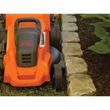 Tondeuse à gazon Black+Decker, électrique, couleur orange et noire, sur pelouse