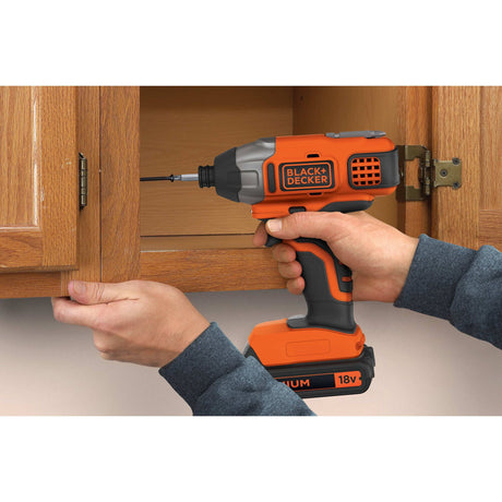Perceuse-visseuse BLACK+DECKER, outil électroportatif orange et noir en utilisation.
