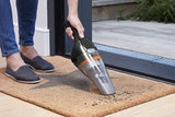 Aspirateur à main Black+Decker, gris et noir, utilisé sur un paillasson