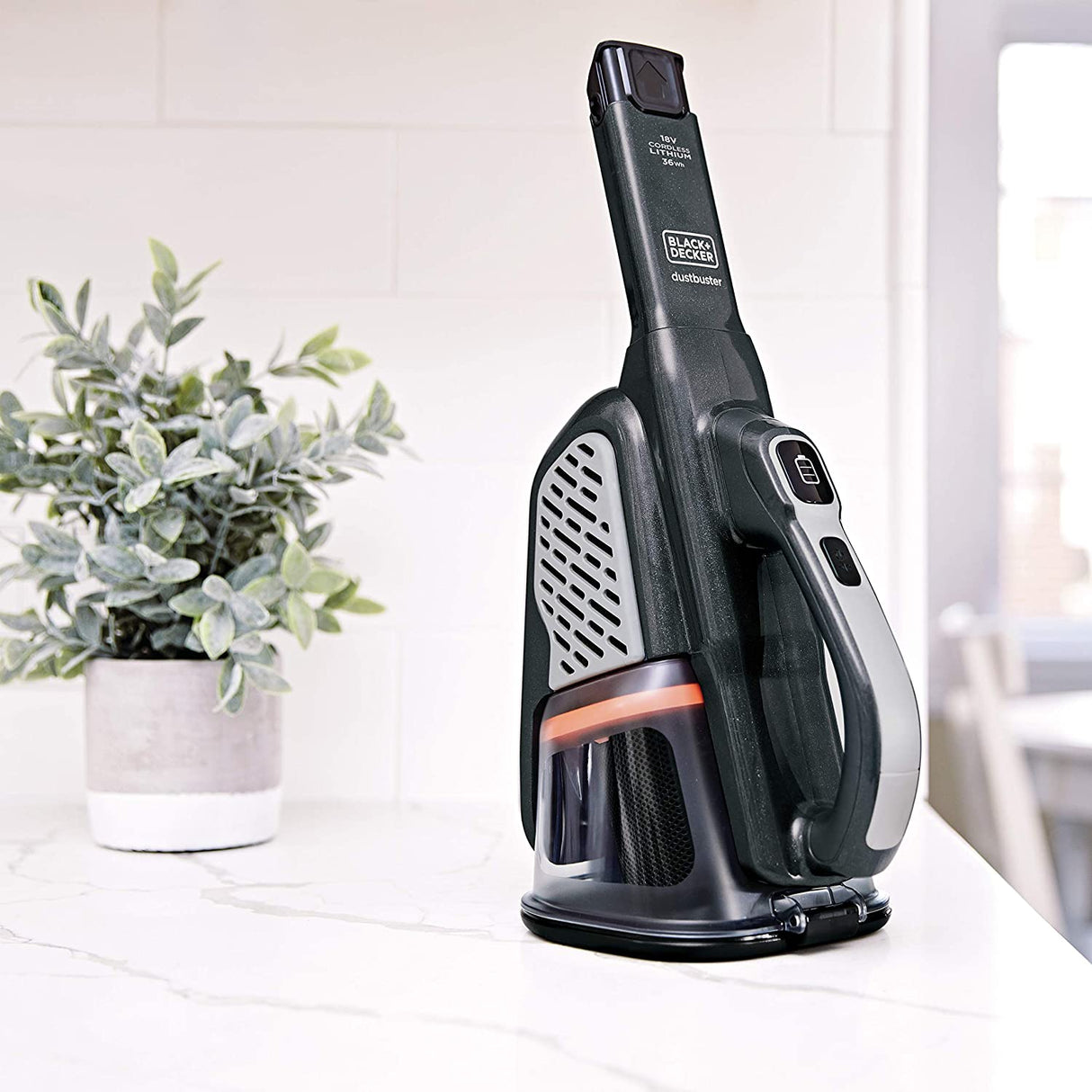 Aspirateur à main noir Black+Decker, Dustbuster, posé sur un plan de travail clair.