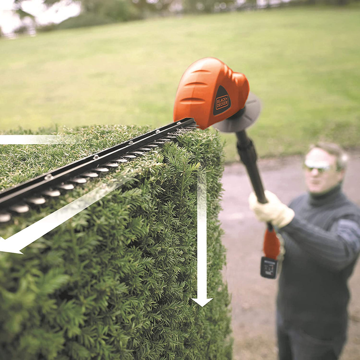 Taille-haie Black+Decker, outil de jardinage, couleur orange et noir, en action sur une haie