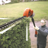 Taille-haie Black+Decker, outil de jardinage, couleur orange et noir, en action sur une haie