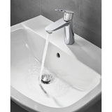 Robinet Grohe, mitigeur lavabo, couleur chrome argenté, eau coulant dans un évier blanc